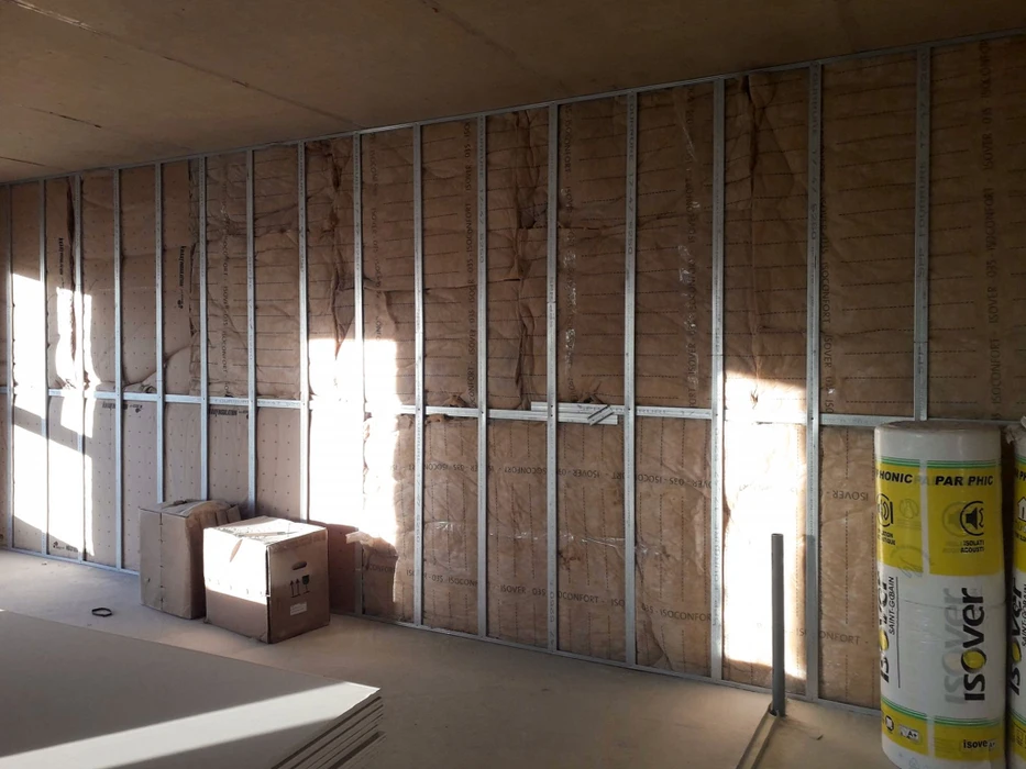 Chantier de construction résidentielle en cours avec extension d'une maison jaune à toit de tuiles