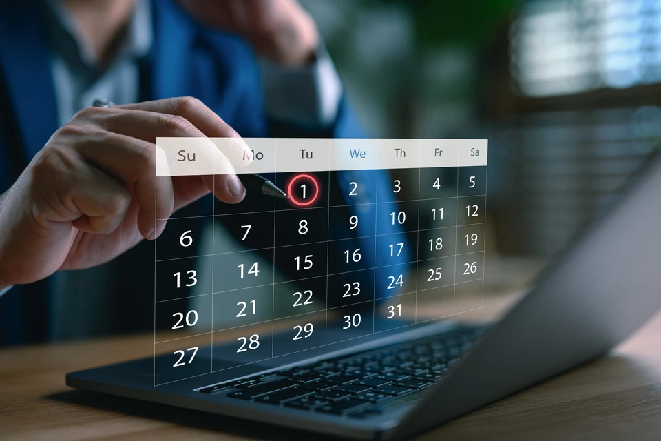 Chantier de construction extérieur avec ouvriers en gilets haute visibilité sur nacelle élévatrice bleue positionnée près d'un bâtiment industriel