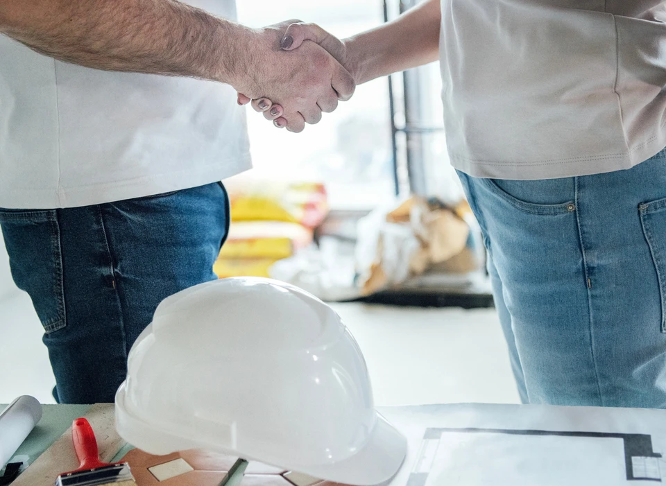 Deux livreurs en uniformes bleus déchargent des colis d'un fourgon de livraison blanc