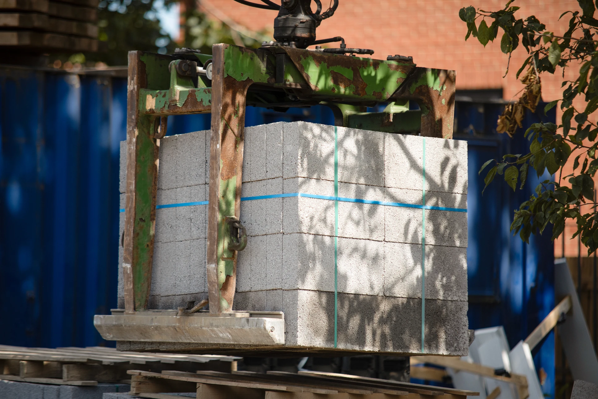 Travailleurs déchargeant une boîte lourde dans un camion de conteneurs